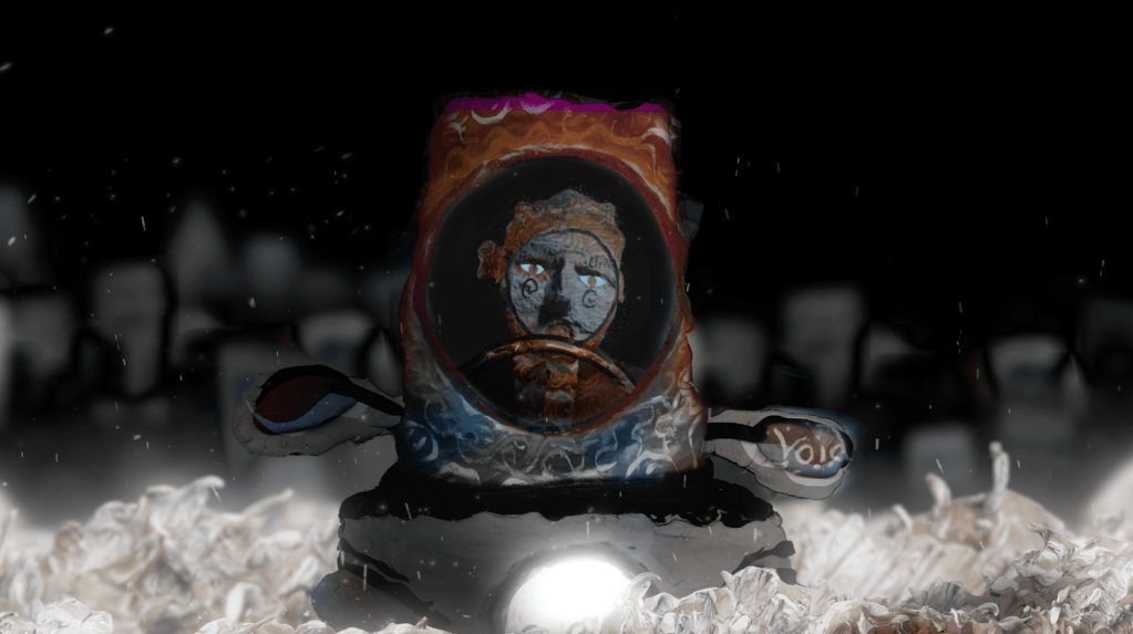 Μία κατασκευή από χαρτόνι επεξεργασμένη ψηφιακά απεικονίζει έναν άντρα μέσα σε ένα μονοθέσιο αυτοκίνητο. Στο νυχτερινό τοπίο με τα κτίρια που χάνονται στο βάθος ξεχωρίζει το φως του αυτοκινήτου που κατευθύνεται προς το μέρος μας. 